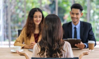 Mujer siendo entrevistada para un trabajo por un hombre y otra mujer. Los entrevistadores parecen estar disfrutando la entrevista.